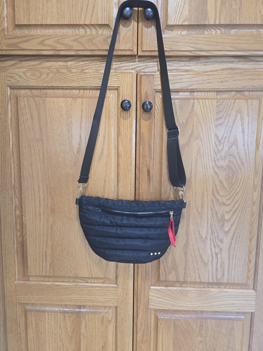 Black Quilted Crossbody Bag with Red Accent Strap Pull
